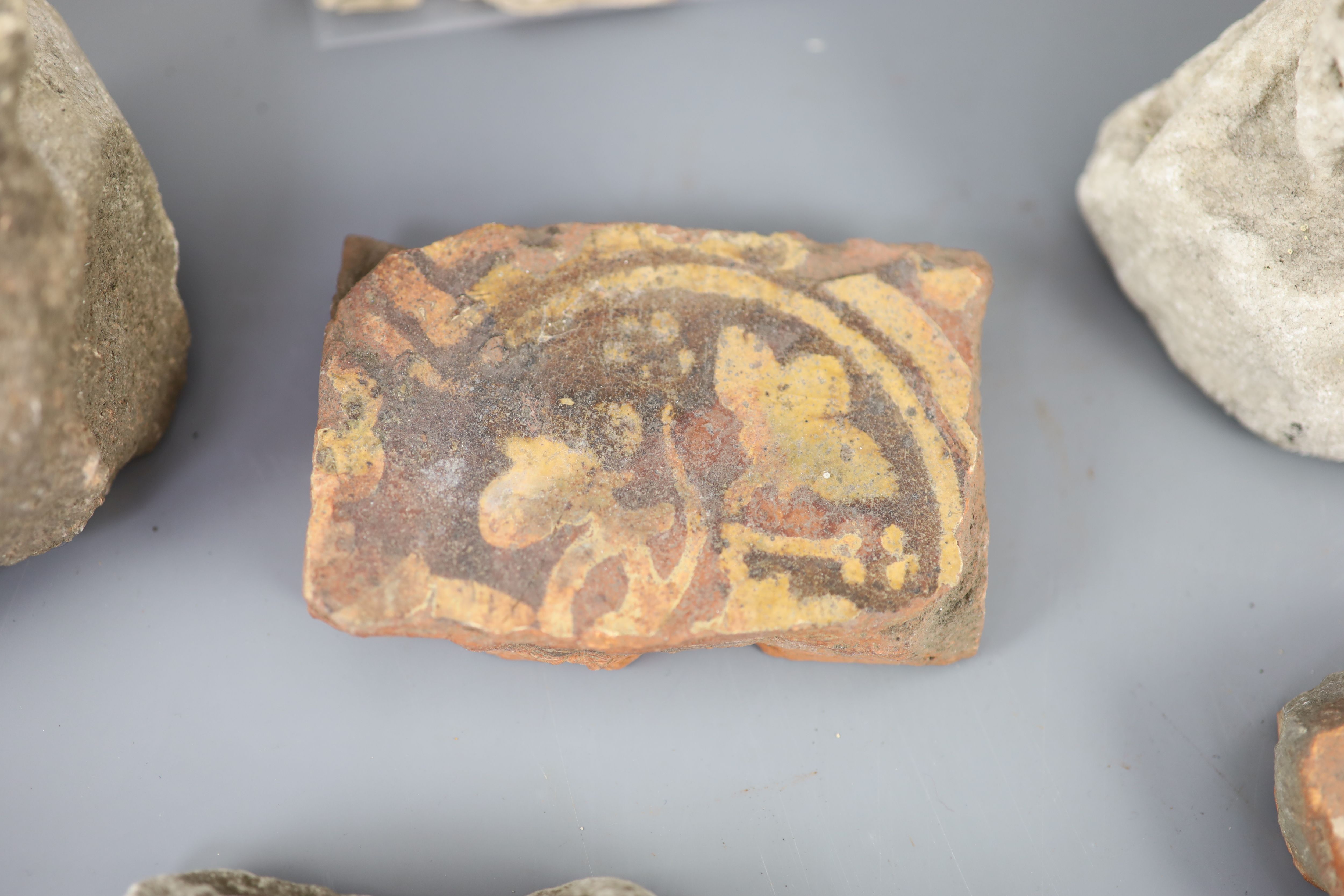 A group of English medieval church/priory architectural stonework and tile fragments, some pieces with inscribed labels of provenance,